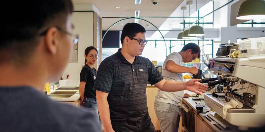 Lim observes Kuan as he operates the coffee machine