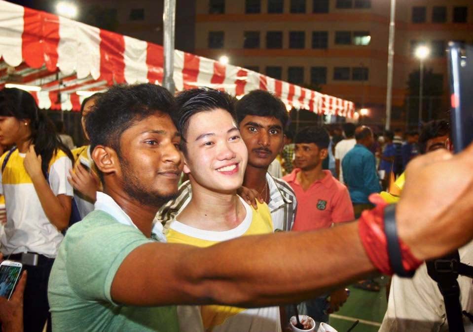 Migrant worker taking picture with volunteer