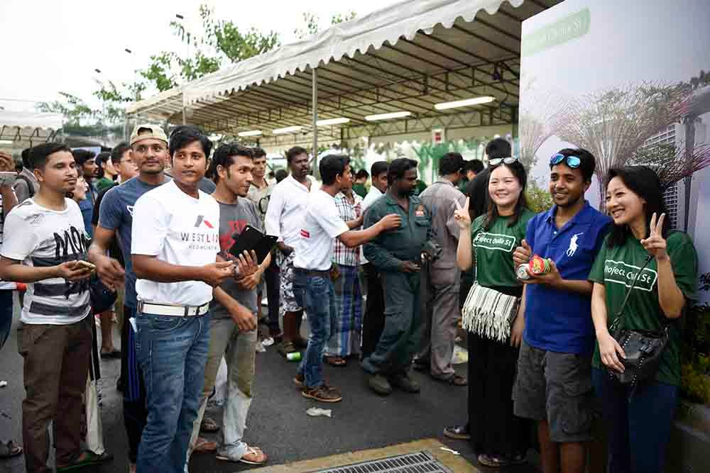 Migrant workers posing with volunteers