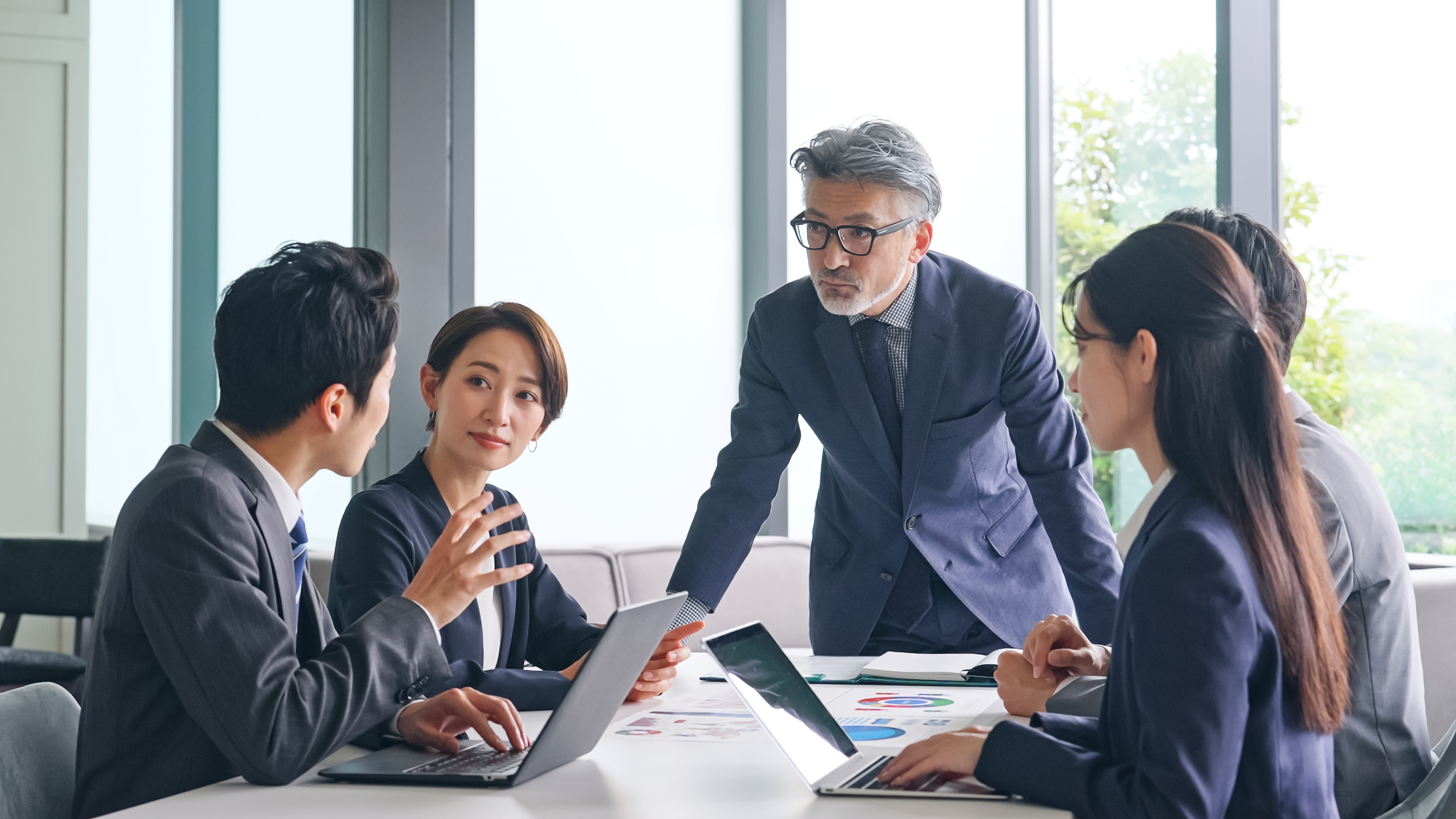 Three business professionals in a meeting, discussing work.
